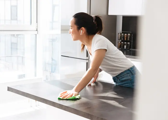 Wiping kitchen counters. Keeping surfaces clean and sanitized are simple ways to prevent ants.