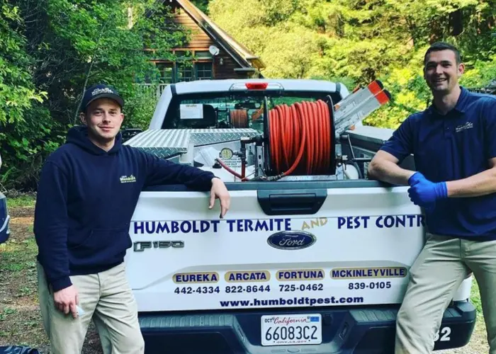 Huboldt Termite & Pest Control technicians standing with service truck after performing a monthly preventative pest check.
