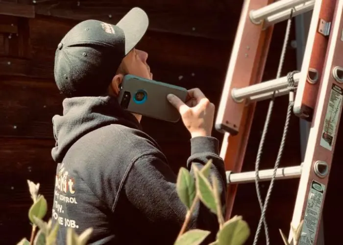 A Humboldt Termite & Pest Control technician climbs a ladder to investigate a pest problem